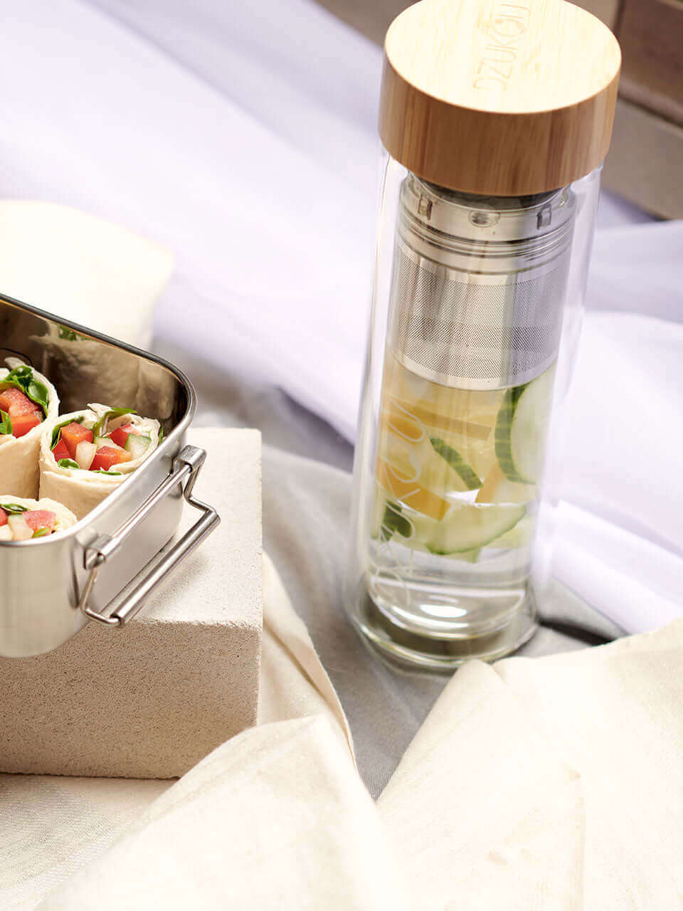 A glass bottle along with a container filled with a variety of food items, showcasing a colorful and appetizing assortment.