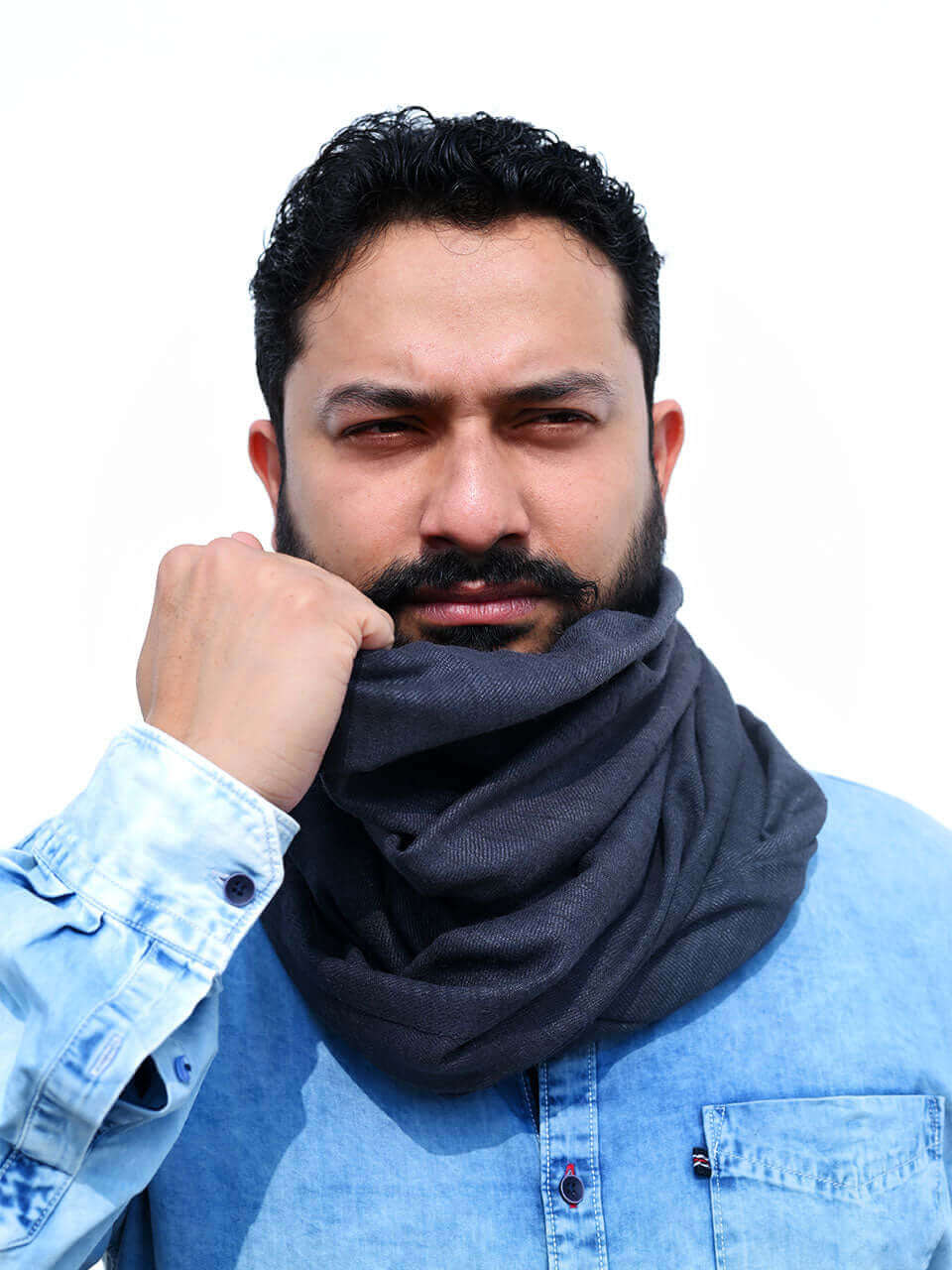 A bearded man wearing a grey scarf around his neck, exuding a warm and stylish appearance.