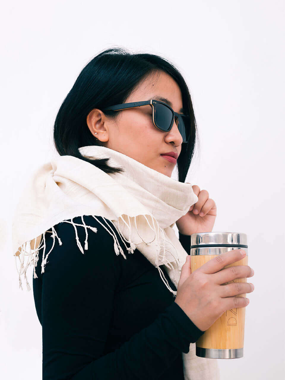A woman wearing a stylish scarf and sunglasses, exuding elegance and confidence in a sunny outdoor setting.