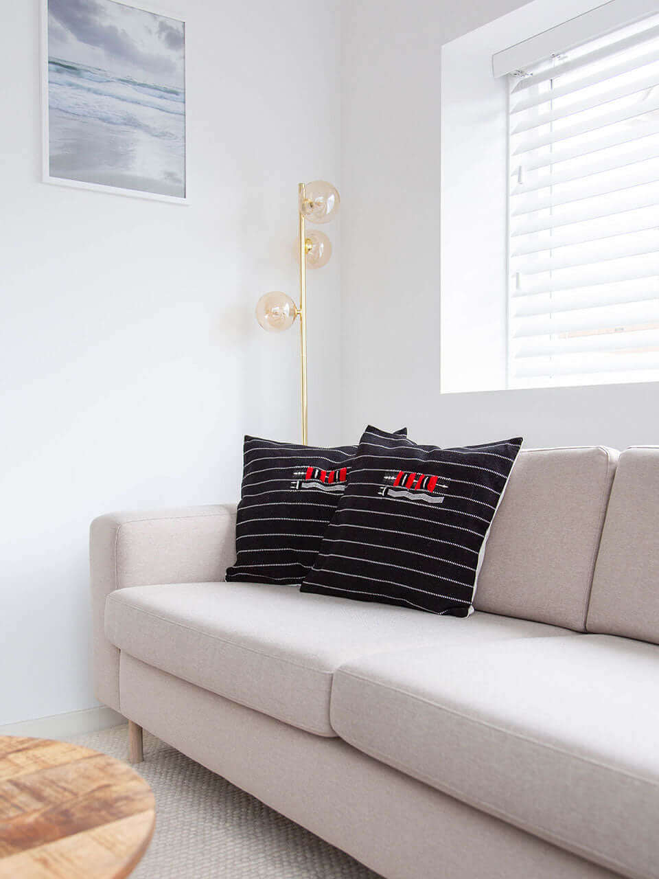 Two black pillow cover featuring bold red and white stripes, arranged side by side on a neutral background.