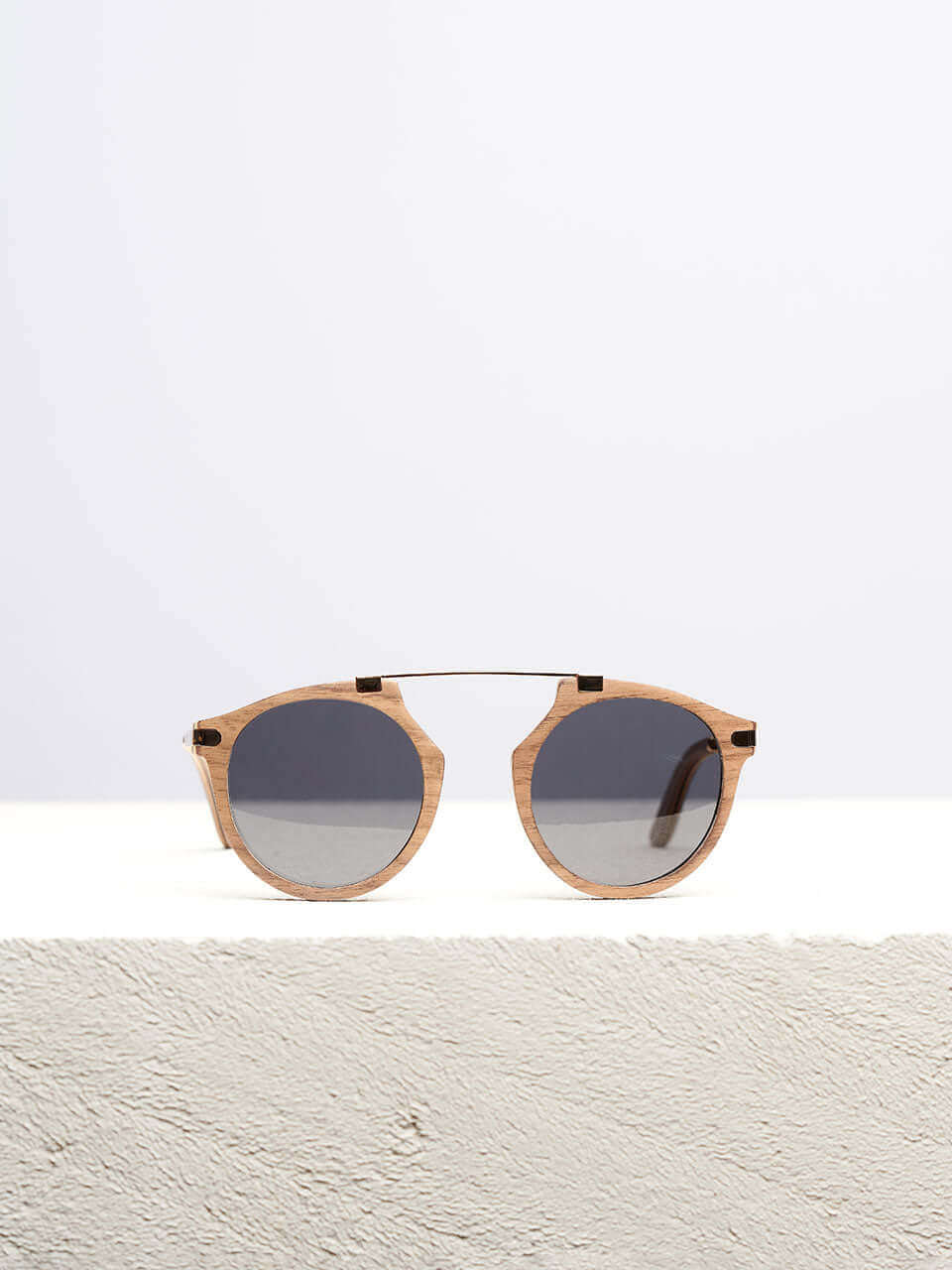 Wooden sunglasses with dark lenses in a neutral background, showcasing a unique and eco-friendly design. Perfect for stylish sun protection.