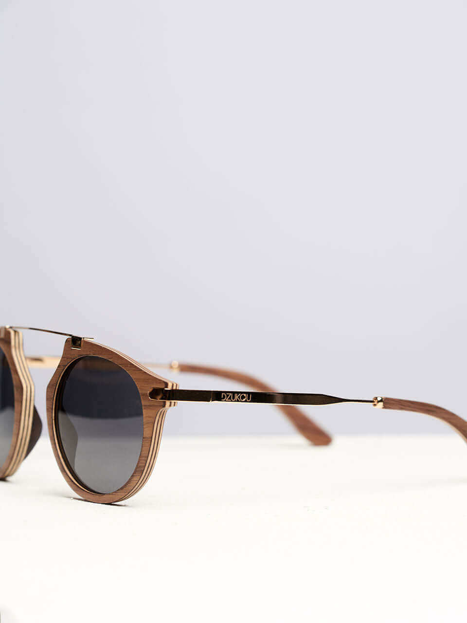 A wooden sunglasses featuring a side view of the stylish wooden frame in a clean surface with a neutral background, showcasing a unique and eco-friendly design.
