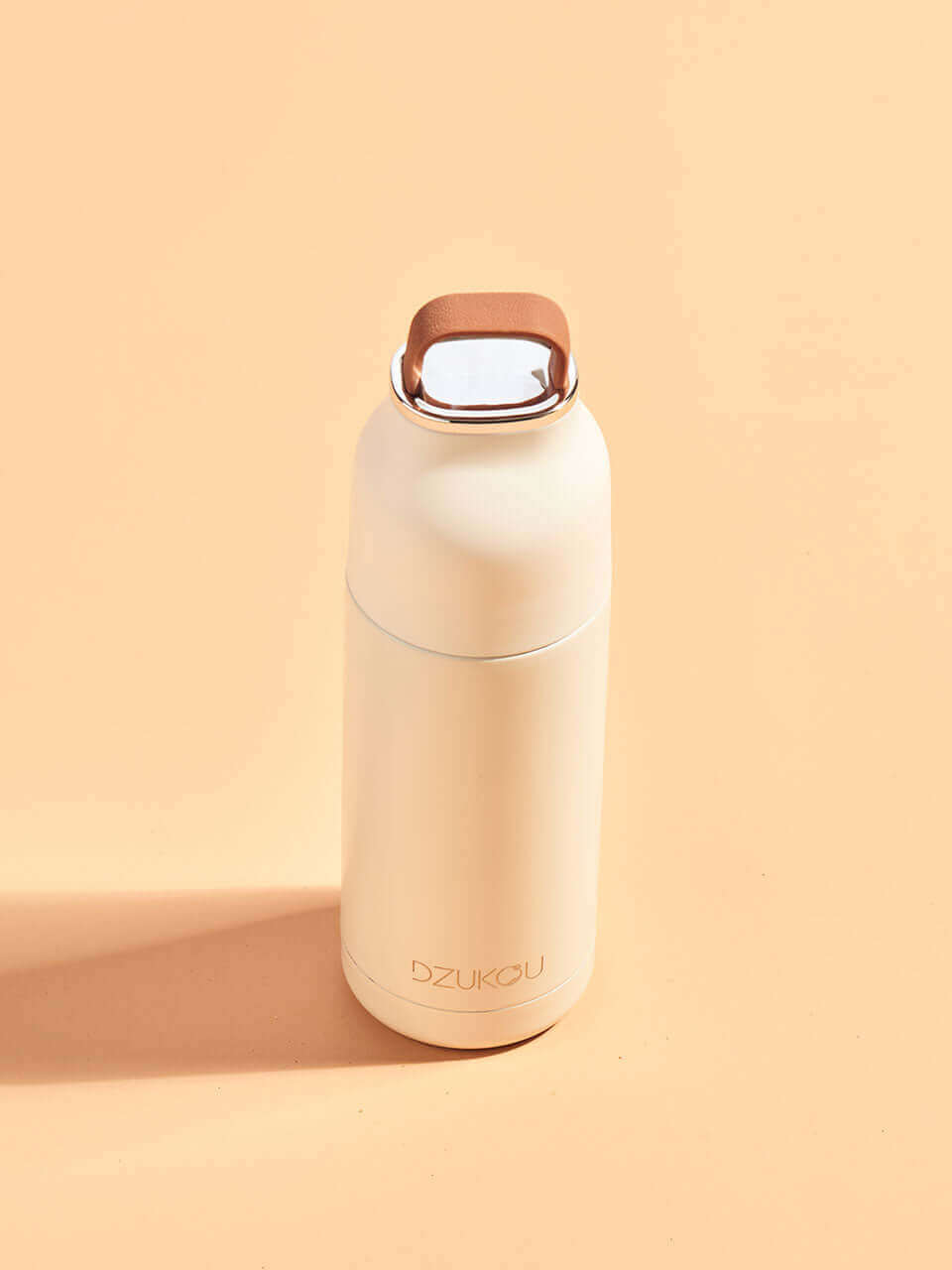 A peach water bottle featuring a handle, showcasing a blend of modern and natural design elements.