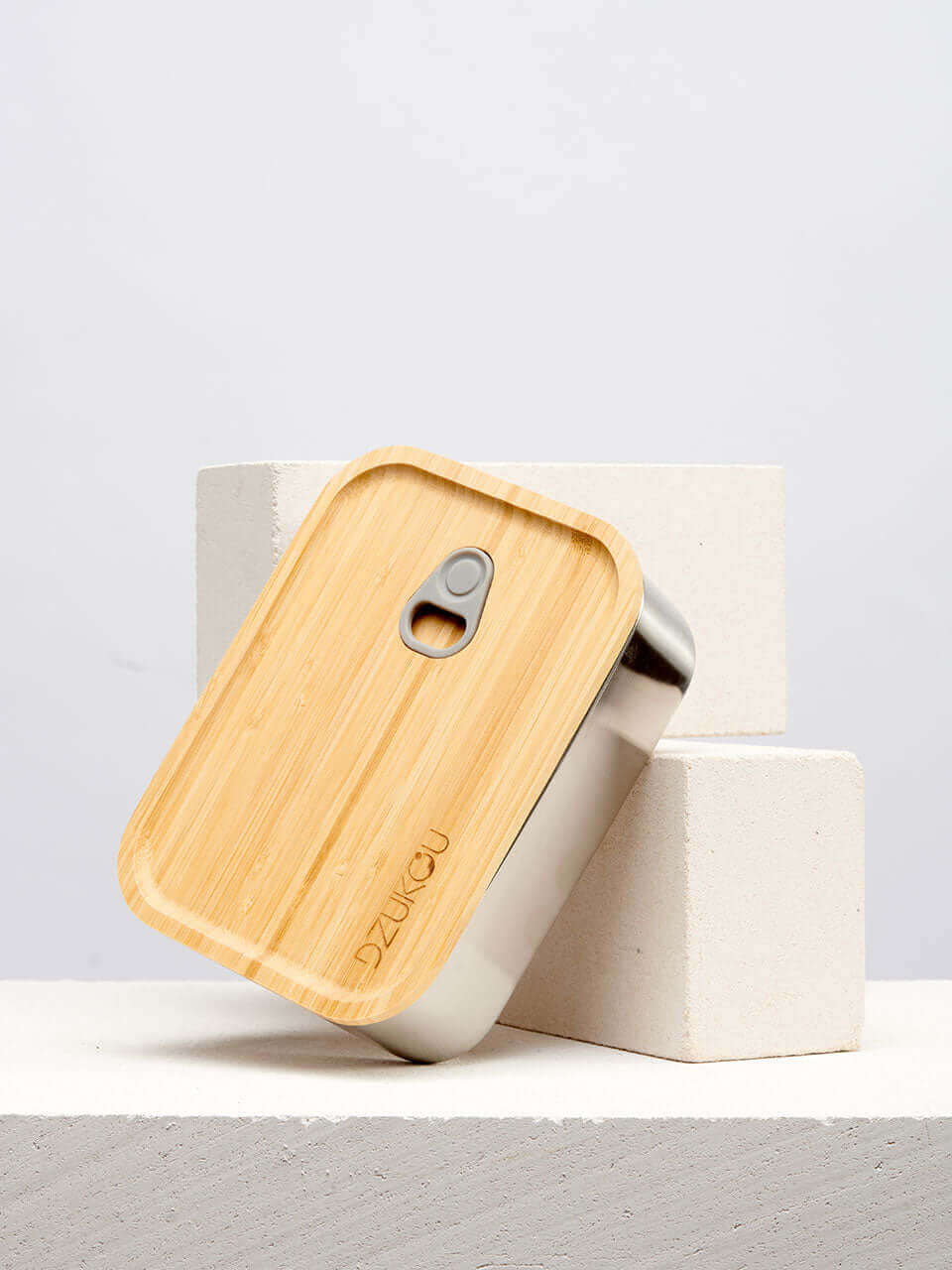 A bamboo lunch box featuring both a metal lid and a bamboo lid, showcasing a blend of materials and craftsmanship.