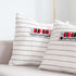 Two white pillow cover featuring bold red and black stripes, arranged side by side on a neutral background.
