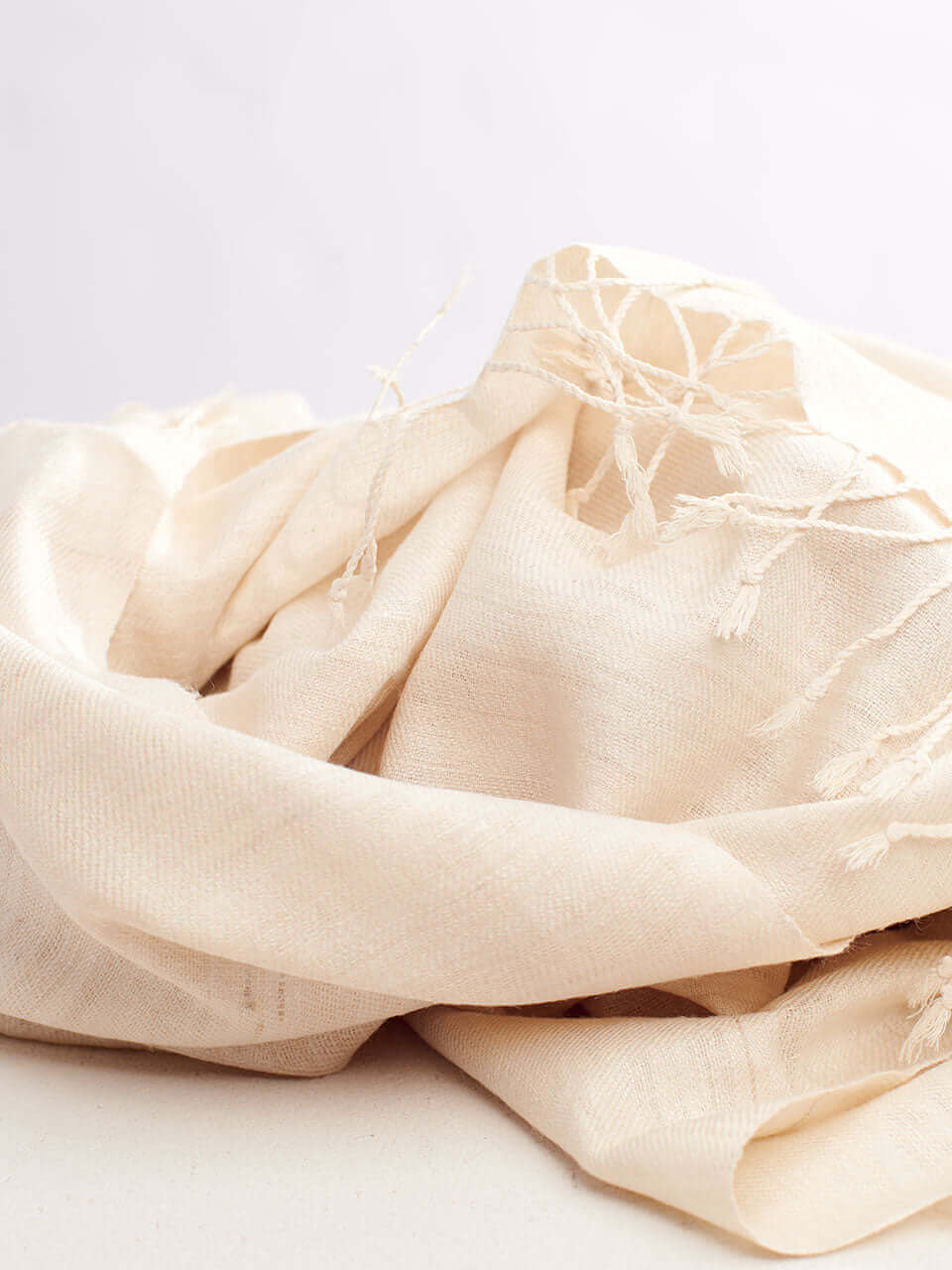 A white scarf elegantly draped over a pristine white table, creating a serene and minimalist aesthetic.