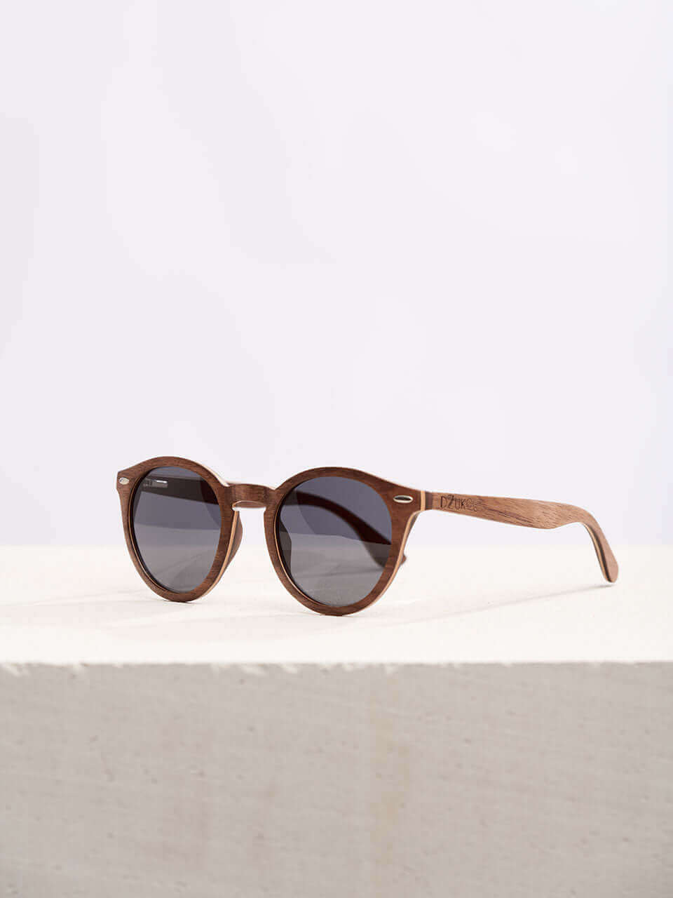 A wooden sunglasses featuring a stylish wooden frame in a clean surface with a neutral background, showcasing a unique and eco-friendly design.