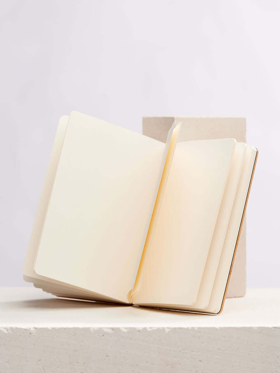 A blank notebook page resting on a clean white block, inviting thoughts and creativity.