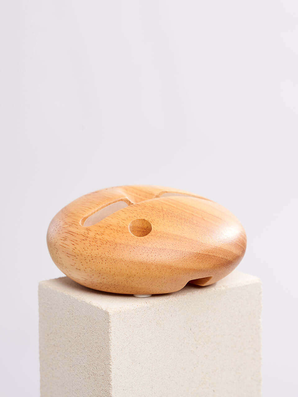 A cell phone stand placed on a white block, showcasing a blend of technology and natural materials.