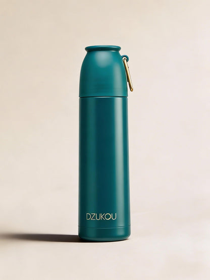 Teal water bottle with gold cap on a beige background