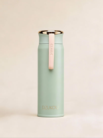 Mint green thermos with pink strap on a beige background