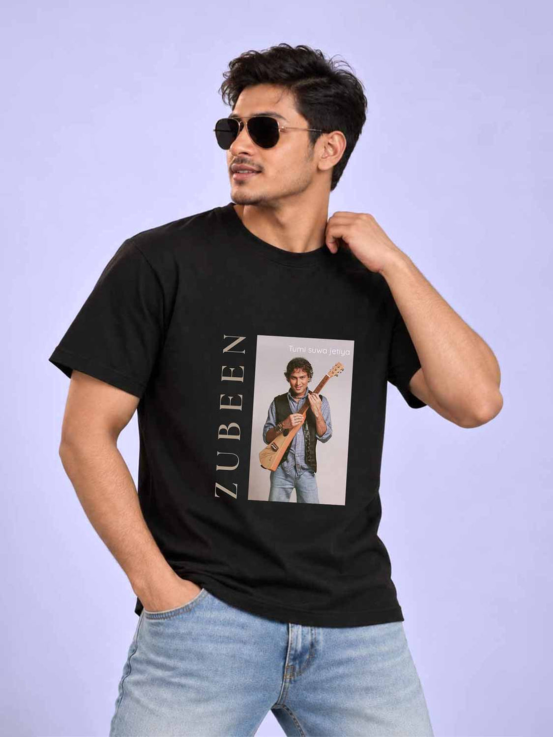 A man wearing a black graphic t-shirt with a photo print of Zubeen and the name &