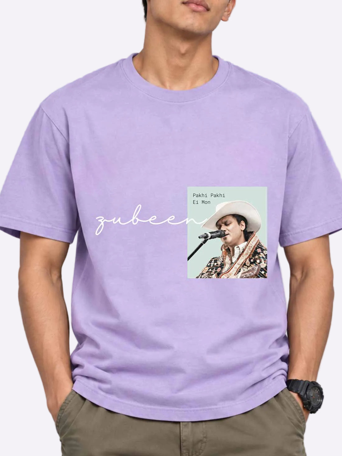A man wearing a lavender purple crewneck t-shirt with a graphic print of the song &