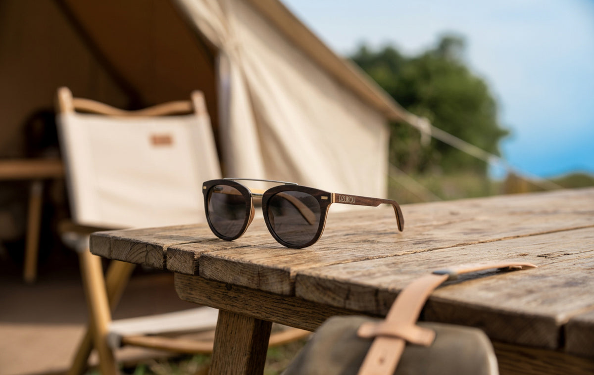 Sunglasses on a wooden table with a tent and chair in the background