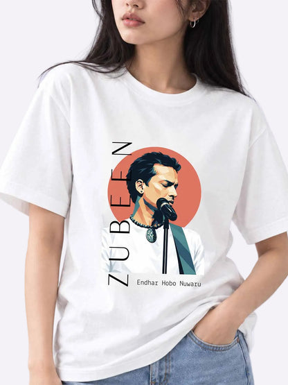A woman wearing a white oversized graphic T-shirt featuring a stylized portrait of a man at a microphone with vertical text reading &