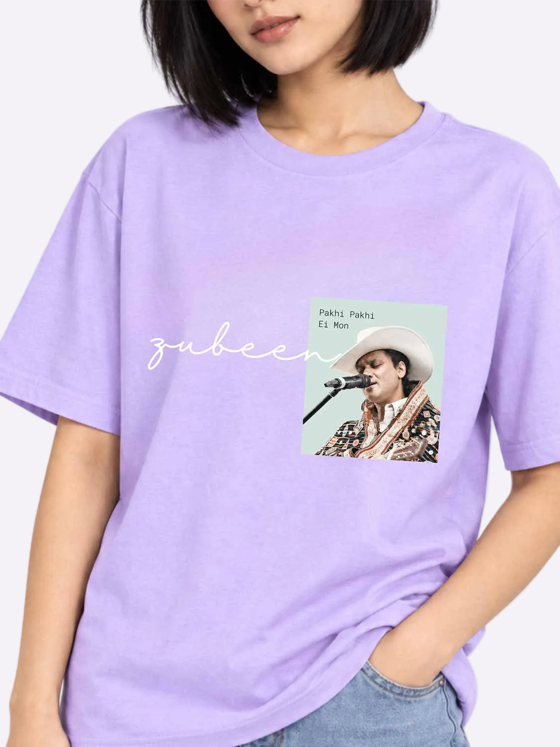 A woman wearing a lavender purple oversized t-shirt with a graphic print of Zubeen Khan&