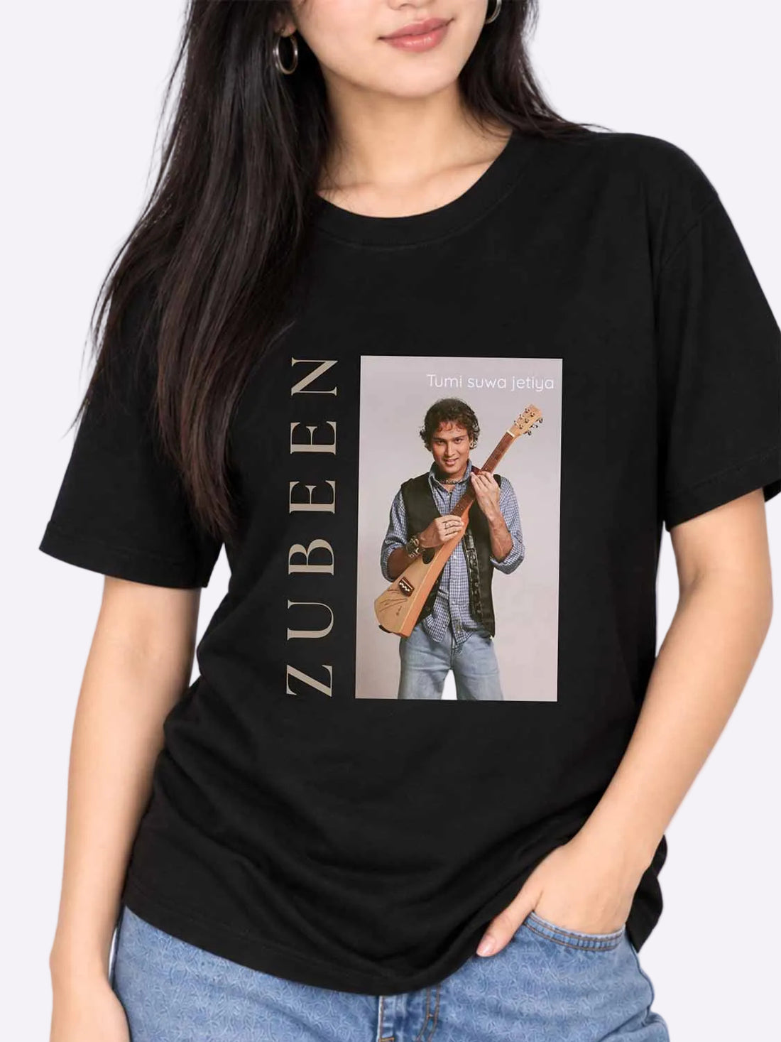 A woman wearing a black short-sleeve graphic T-shirt with a large front print featuring the name &