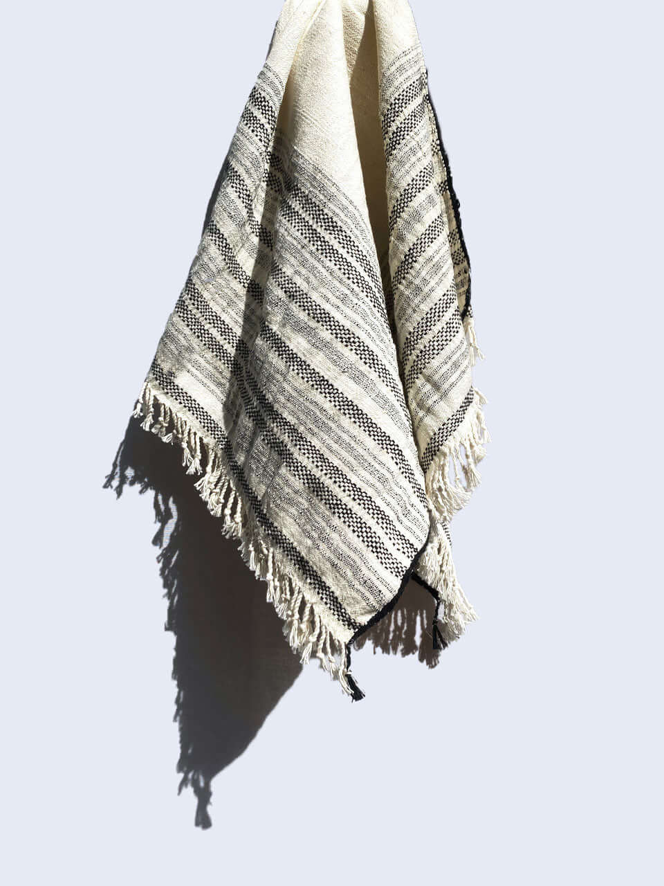 A black and white striped organic cotton hand towel elegantly displayed on a wall.