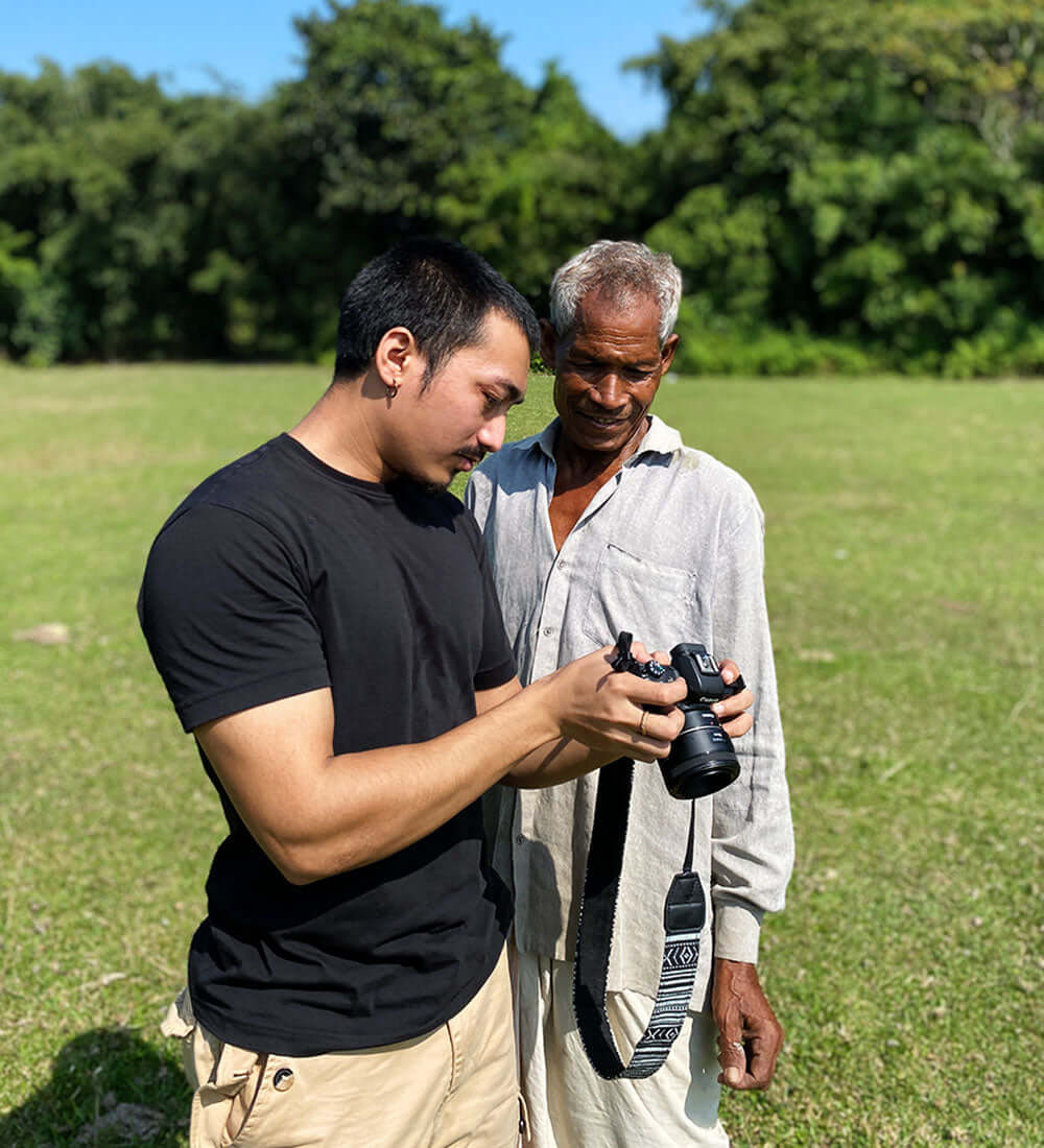 a photographer showing pictures to a villager