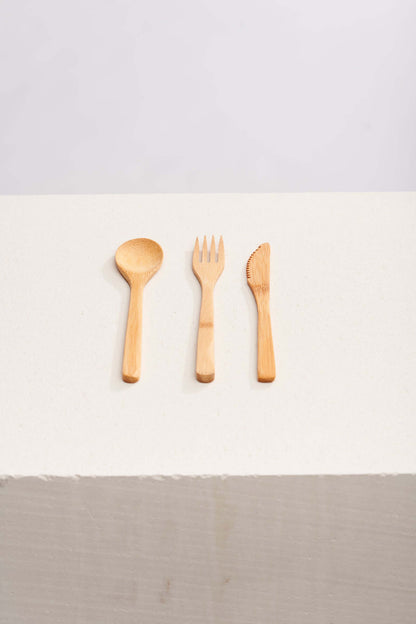 A set of three wooden spoons and forks arranged neatly on a light background