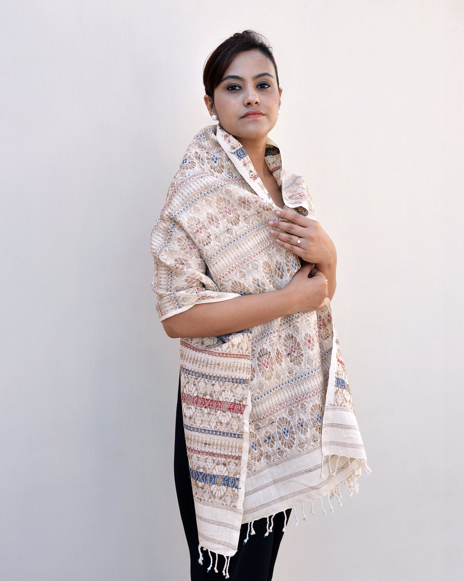 A woman elegantly draped in a white and blue scarf, showcasing a blend of colors and style.