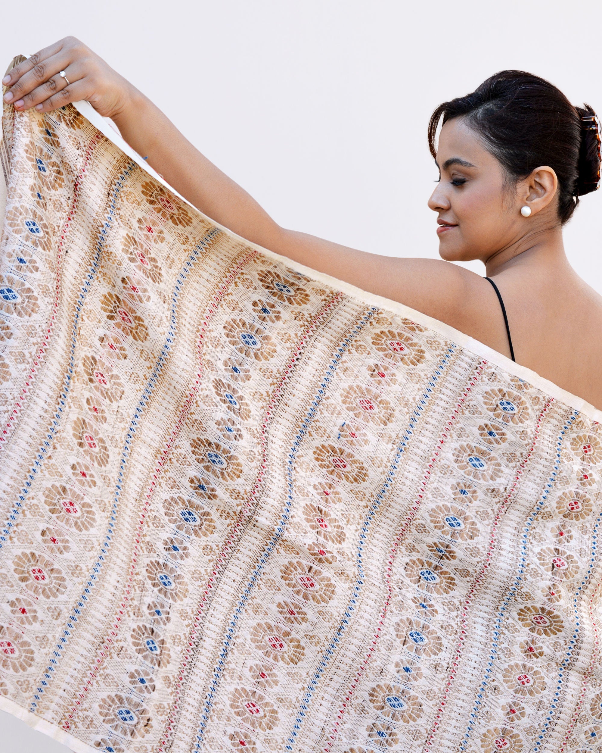 A woman elegantly draped in a white and blue scarf, showcasing a blend of colors and style.