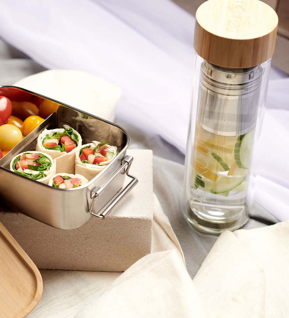 glass bottle and a lunchbox with veggies