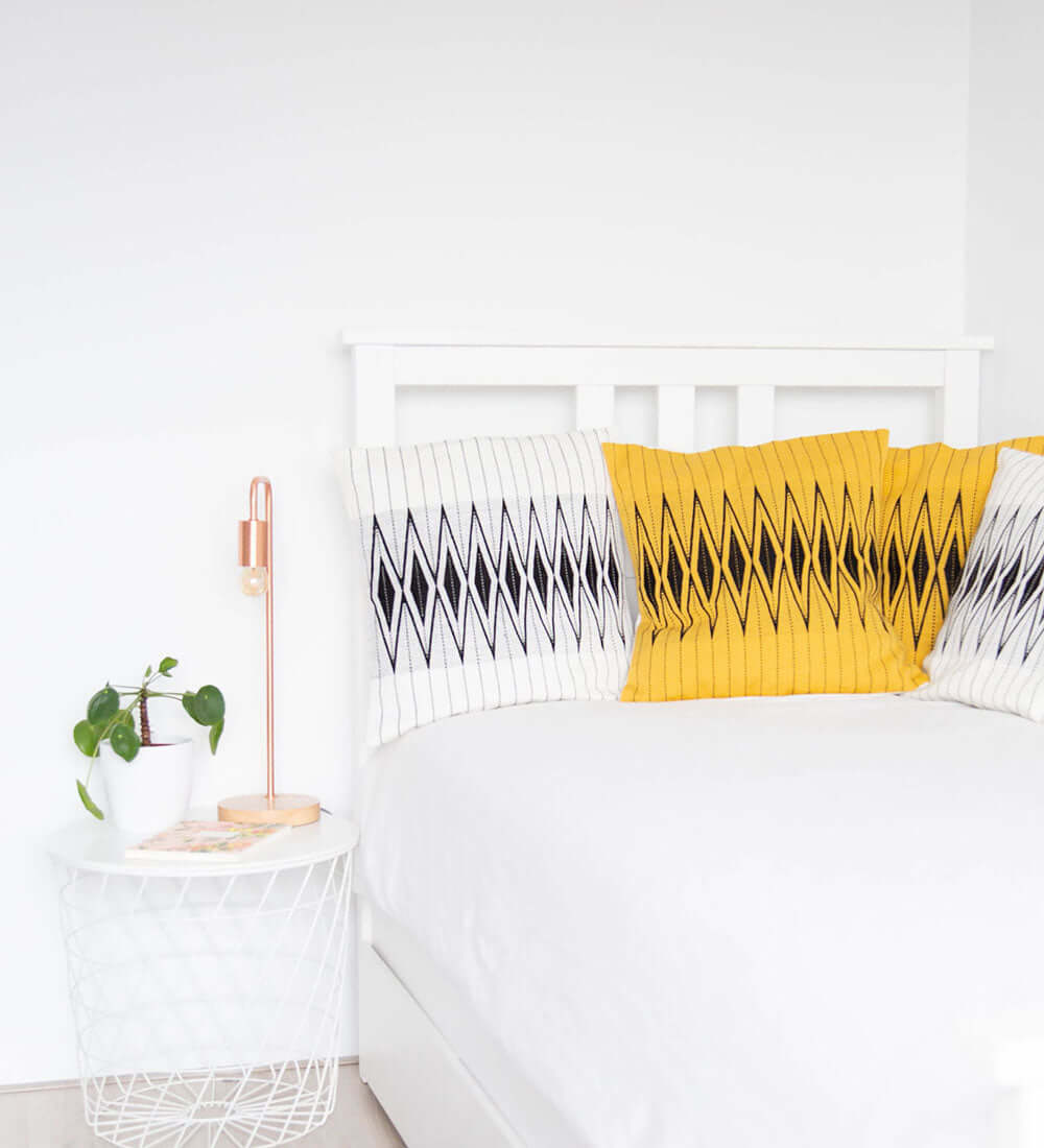 a few cushions of yellow and white colours kept together