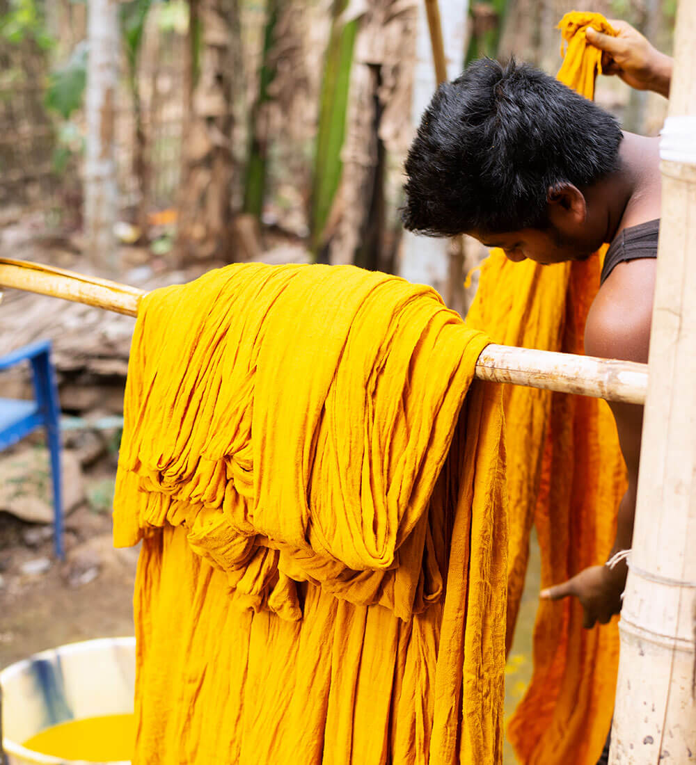 worker dyeing a yellow silk stole