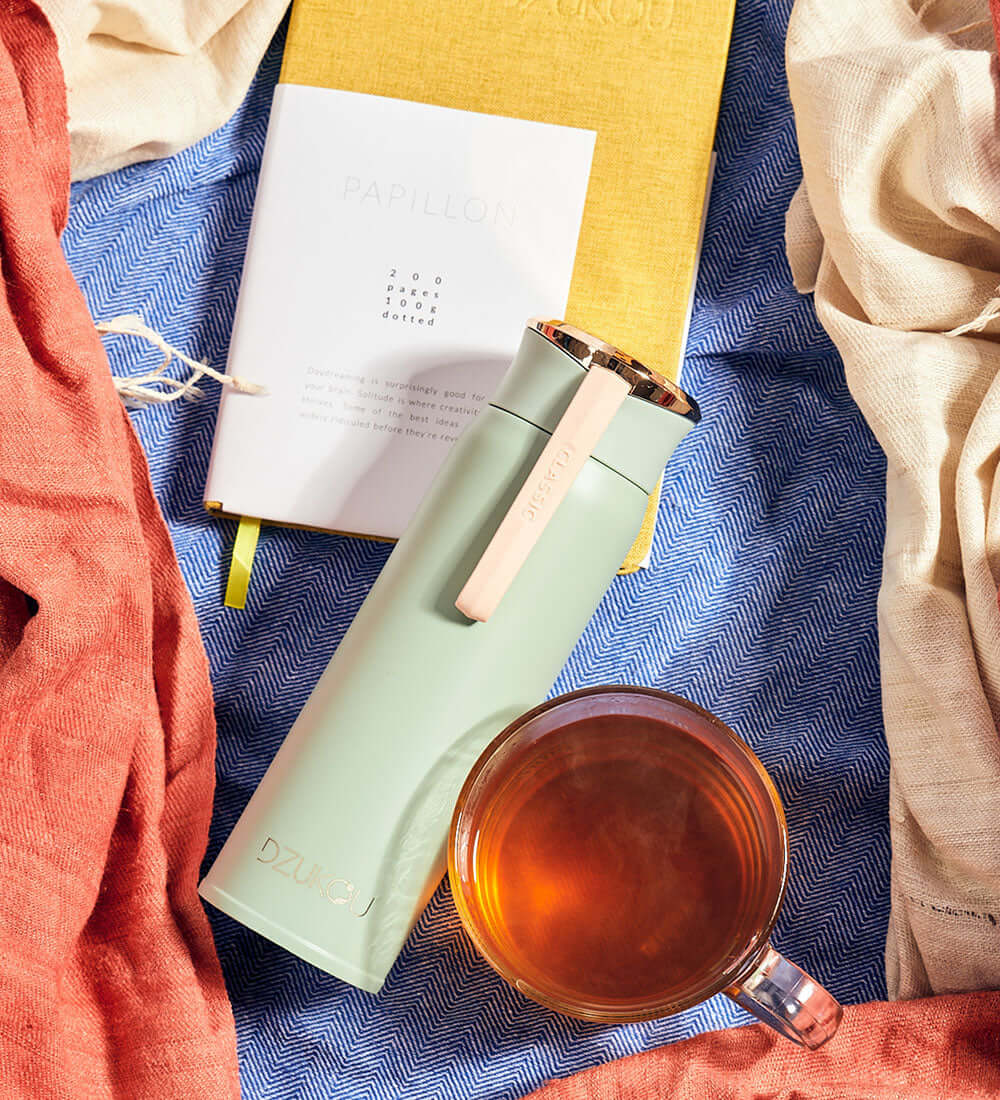 notebook, and a bottle kept near a cup of tea