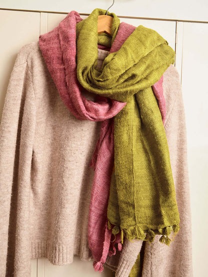 An olive Eri silk shawl hanging on a cabinet, highlighting its soft texture and natural color.