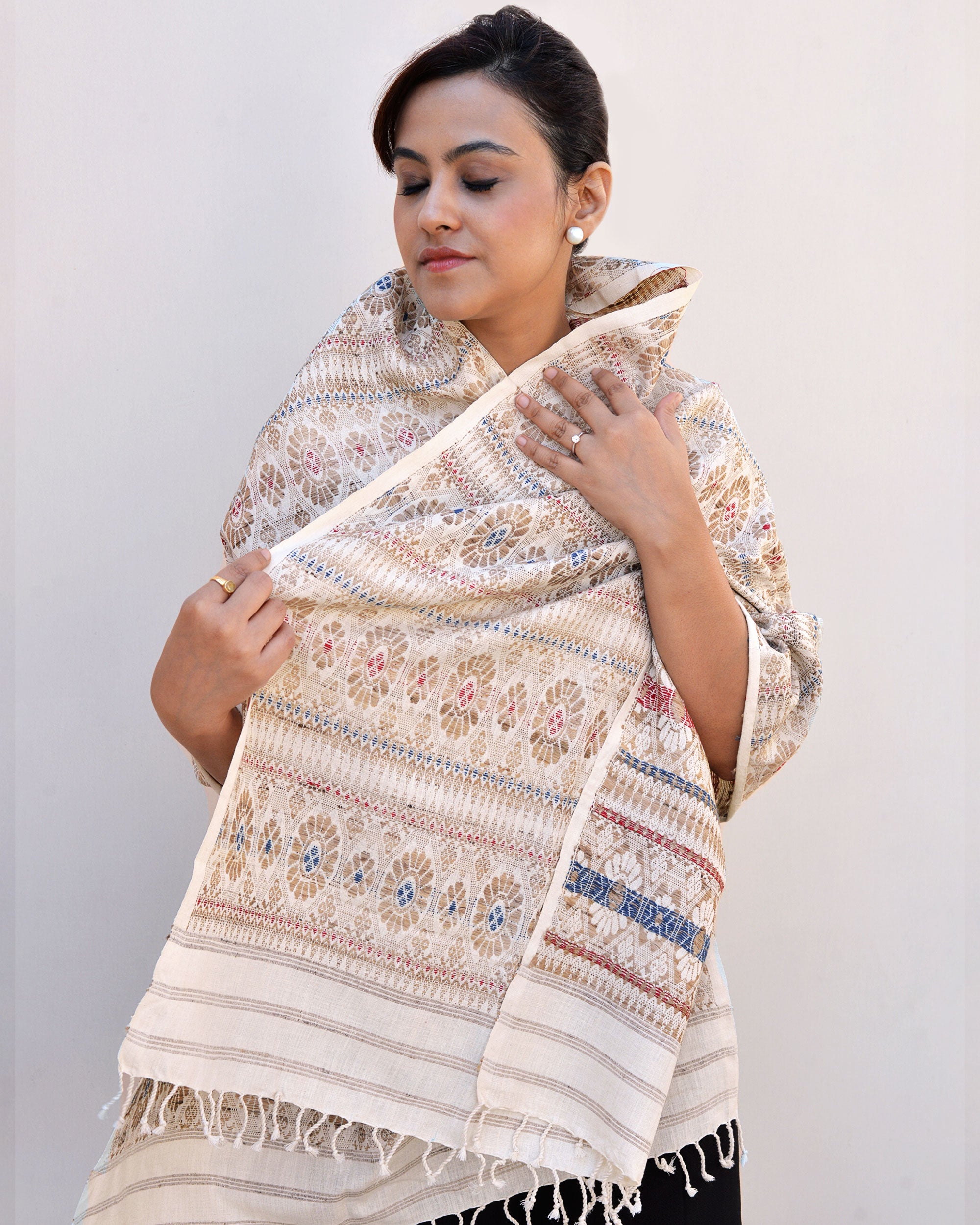 A woman elegantly draped in a white and blue scarf, showcasing a blend of colors and style.