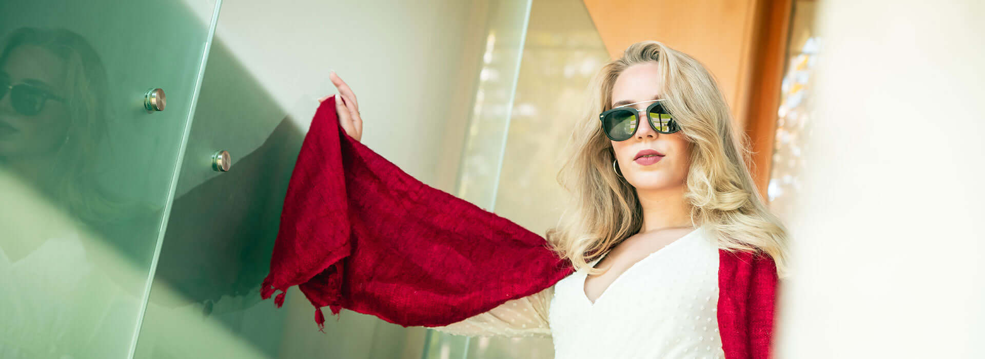 woman wearing sunglasses wrapped up a red stole 