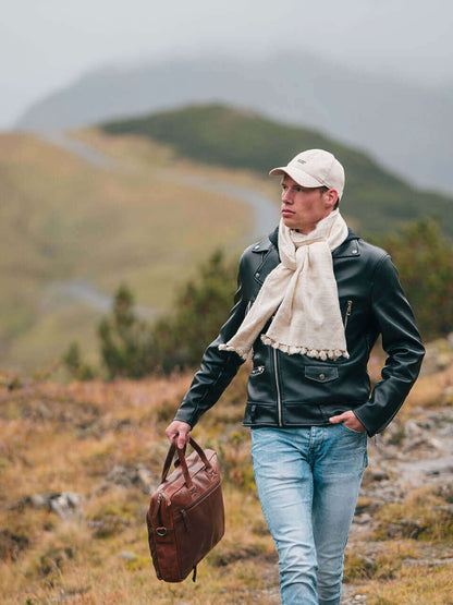 A man draped in a soft, elegant white Eri silk shawl, showcasing its smooth texture and natural color.