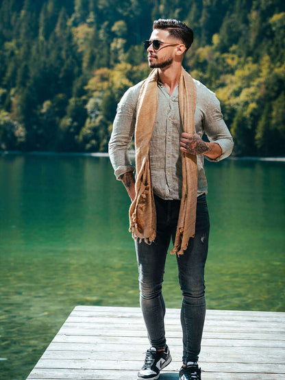 A man draped in a soft, elegant beige Eri silk shawl, showcasing its smooth texture and natural color.