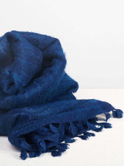 A blue Eri silk shawl spread out on a surface, highlighting its soft texture and natural color.